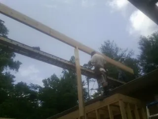 Carpenter setting a ridge beam over a new addition frame — Ice Dam Removal by Roofing Brothers in Eufaula