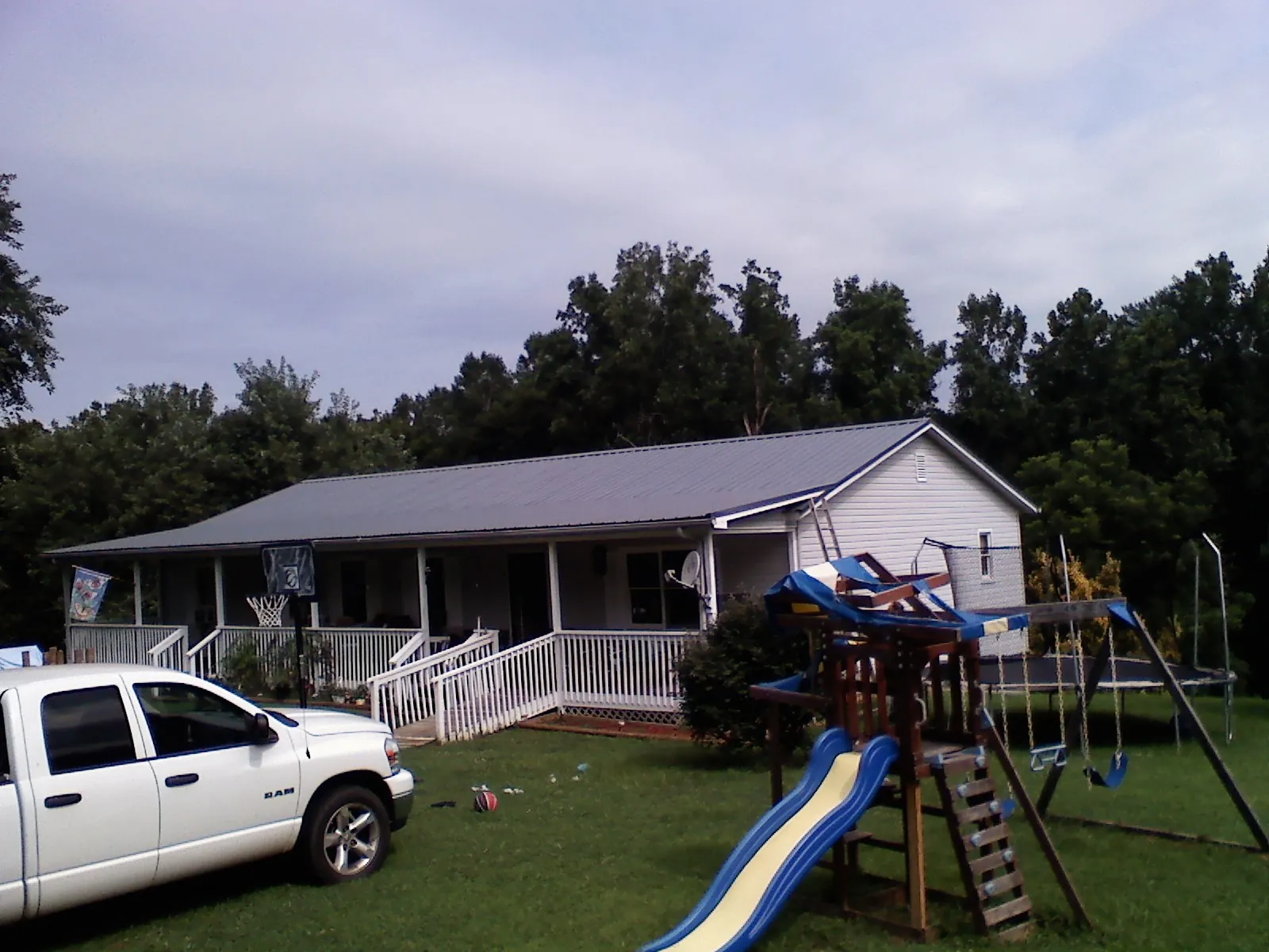 Dark metal roof on a country home with a full length front porch in Eufaula