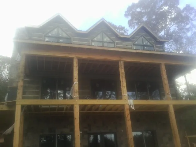 Dormers and porch framing on a large log home under construction — Roof Coating work by our crew in Eufaula