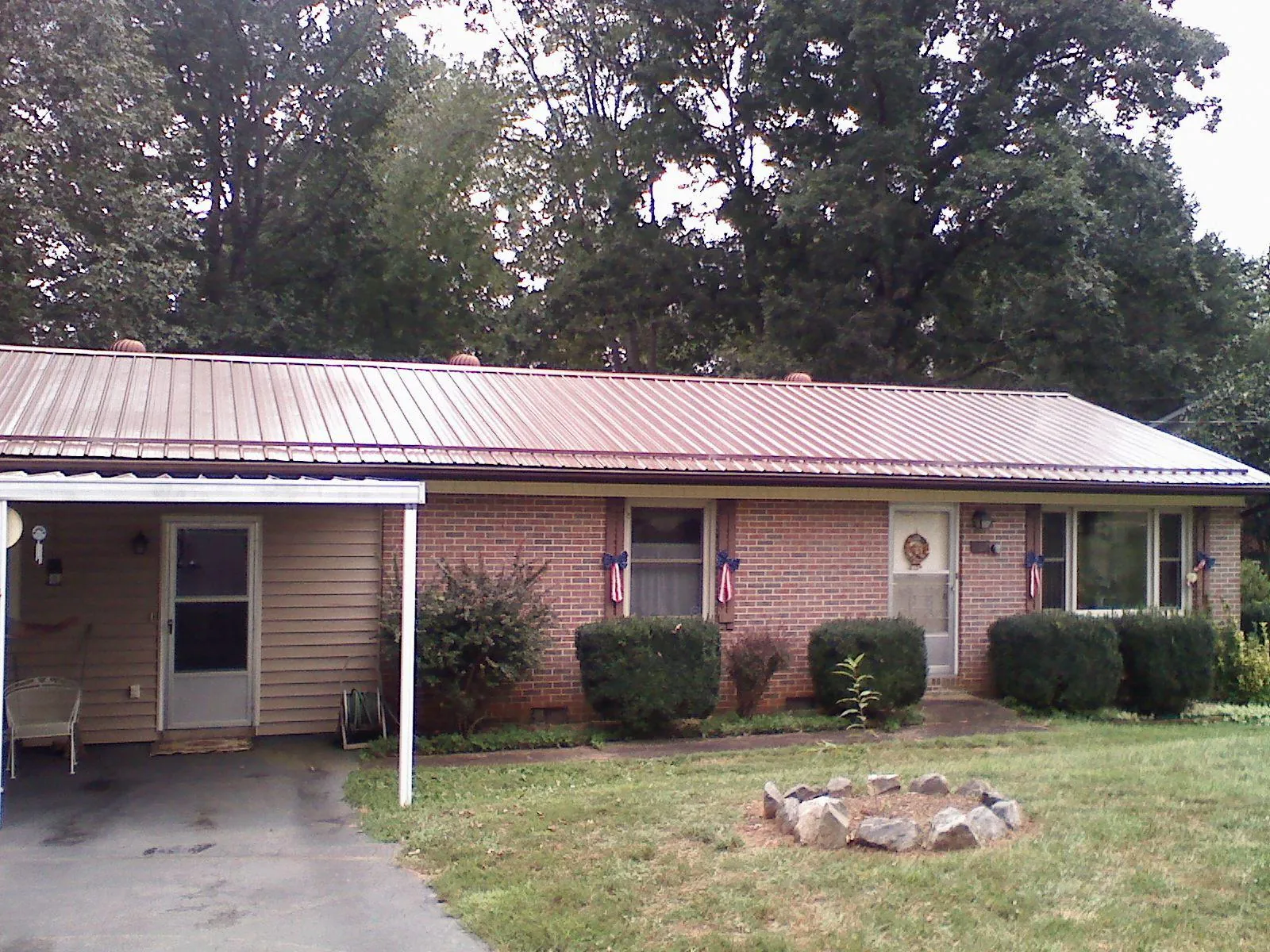Bronze metal roof and carport on a brick ranch home — Roof Repair work by our crew in Eufaula
